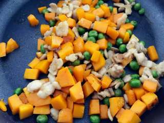 3、宝宝辅食：南瓜苹果炊饭,下南瓜丁和甜豌豆，翻炒至南瓜变软，小芽中火大概翻炒了5-6分钟左右。