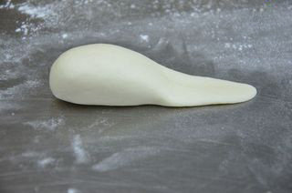 5、小兔包子,把包好的面团先搓成椭圆形，再把一边搓细压扁