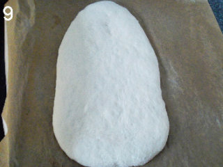 9、法式面包Fougasse 香油蓝乳酪版,面团翻面，收口朝下，用擀面杖擀开。不用太薄，但也别太厚。半厘米的样子。放在铺了烘焙纸的烤盘上。表面搭上亚麻布，发酵45分钟