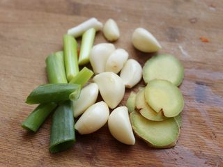 8、酱汁焖锅,准备大蒜头，葱段和姜片。