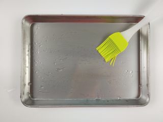 5、自制鸡蛋青菜肠粉,用油刷在蒸盘上刷上薄薄的一层食用油。