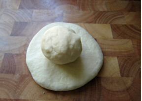 3、葵花酥 ,两个面团盖上保鲜膜，松弛30分钟后，将水油皮拍成大饼，包上油酥皮