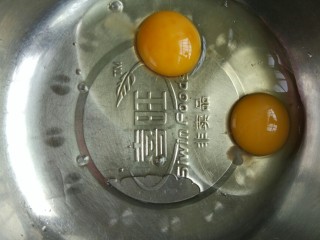 3、胡萝卜甜甜圈（免油炸烤箱版）,两个鸡蛋装入不锈钢盆中，用手动打蛋器搅拌均匀。