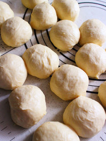 4、沙茶玉米手撕餐包 ,面团取出放置工作台上,排气后分割成每个约50g的小面团,滚圆后加盖松弛约15分钟