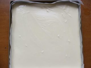 7、芒果盒子蛋糕,将蛋糕糊倒入方形烤盘里。烤盘记得事先垫一张油纸。蛋糕糊倒入进去后，用刮刀将蛋糕糊抹向四周，然后将烤盘在台面上轻震几下，震出大气泡