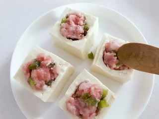 2、宝宝辅食：豆腐箱（肉末酿豆腐）,把步骤2中备好的猪肉糜填入，和豆腐块表面平齐稍稍多出一点点即可。