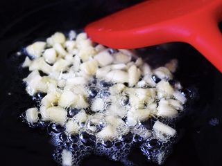 5、蚝油茼蒿肉丝豆干小炒,把切碎的大蒜放入锅中煸炒出香味