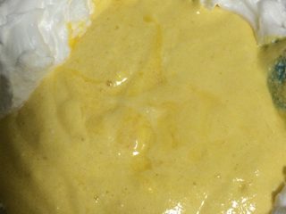 7、葡萄干戚风蛋糕,如图将上述面糊倒入剩下2/3蛋白中，继续用上下翻拌的手法拌匀；