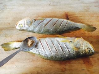 5、#感恩节食谱# 香煎小黄鱼,在鱼身上的两面和内脏部位都抹上少许白胡椒粉。
