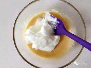 6、芝麻牛奶华夫饼,取一部分蛋白霜放到步骤3的蛋黄糊中，用橡皮刮刀翻拌、切拌均匀。