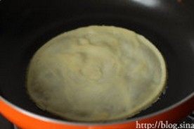 7、水果千层蛋糕,将冷藏后的面糊舀入锅中，用手举着锅子晃开面糊，摊开