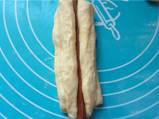 7、自制健康油条,中间用筷子压一下,用手捏住两端,轻轻拉长。