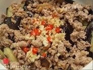 11、咸鱼茄子煲,将辣椒、蒜蓉与姜蓉倒在茄子上，倒入调配好的酱料。