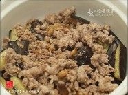 9、咸鱼茄子煲,将猪肉与咸鱼倒在茄子上。