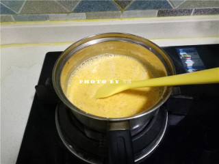 6、椰蓉南瓜糕,将奶锅置于火上，小火加热；一边加热，一边用刮刀搅拌均匀；防止粘锅；