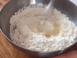 7、零失败超简单的软香小松饼,面粉和泡打粉过筛，倒入翻拌均匀；可以用手动打蛋器把干粉逐步刮刀蛋糊里；