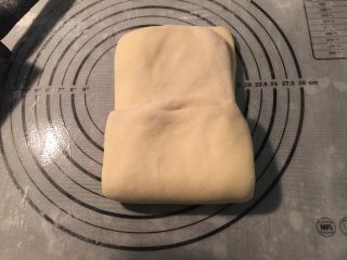 6、起酥手撕包,用擀面杖把包好黄油的面片，擀开成长方形薄面片，从面片的一端1/3向中间翻折，另一端也从1/3处向中间翻折。这是第一次三折；再用擀面杖擀开三折