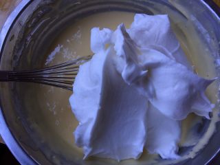 5、缤纷水果奶油蛋糕,将三分之一的蛋白霜拌入蛋黄糊中，右手拿着手抽沿着容器内壁向下，然后再由底向上拌匀蛋白霜和蛋黄糊形成蛋糕糊，左手逆时针转动容器，右手的动作靠手