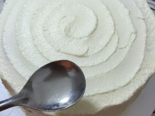 17、缤纷水果奶油蛋糕,表面画圈处理，从边缘开始，圆勺底部接触蛋糕固定在一个点，转动裱花台，如此操作直到中心位置