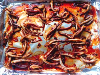 7、再也不用出门去排队买的香辣鱿鱼须（烤箱版）,取出烤盘，这时候烤的鱿鱼须还是比较嫩的。