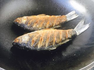 7、#感恩节食谱# 红烧鲫鱼,当鱼的一面煎至金黄色时翻过来再煎另一面，两面都煎至金黄色就OK了。 温馨提示，当把鱼刚刚放到锅里后千万不要急于翻动，如果翻动了，肯定会粘锅的，因为油很热，鱼和铲子都是凉的，热油一下子就会“抱住”铲子和鱼，肯定会粘锅。那么我们什么时候才能翻动鱼呢，1，中火煎制至少1分钟后才能翻动。2，还有就是被煎鱼的那面两边会有明显的金黄色才可以翻动。3，再有就是当离火晃动锅时，鱼可随意在锅里滑动也可以翻动。建议初学者用第2种方法判断。 温馨提示，如果小伙伴选择的是大条的鱼，在翻动鱼时请用两把铲子翻动。