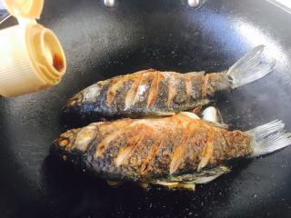 12、#感恩节食谱# 红烧鲫鱼,打开锅盖后，倒入1勺生抽。