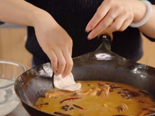 9、地锅鸡【曼食慢语】,将小面球拿出来按扁，再用手直接扯成椭圆形的饼，然后贴在锅边，让饼一半贴在锅边一半飘在汤上