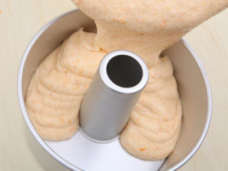 12、南瓜戚风 ,将面糊倒入模具中，稍稍晃动模具，用手按住“烟囱”由上自下震几下。