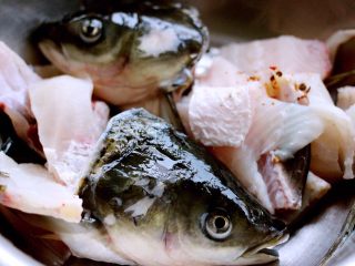 5、#辣味#麻辣水煮鱼,鱼头和鱼排加少许盐和料酒拌匀后腌制10分钟