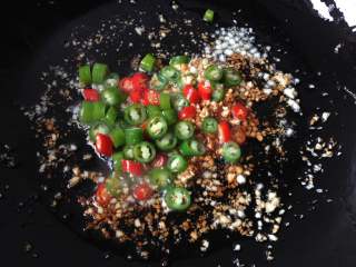 6、蒜香金针菇,放入杭椒和小红椒煸炒一会