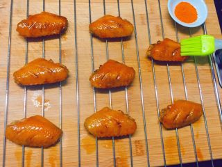 13、美味烤鸡翅,10分钟后,戴上烤箱专用手套,取出烤网,先在鸡翅上刷一层油,再撒上香辣孜然调味粉。然后将烤网再次放入烤箱中层,上下火210度烤10分钟即可出炉。