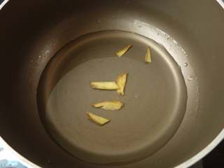 1、三鲜炒年糕,用小许水、姜片煮沸