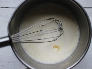 5、葡萄干奶冻,然后趁热加入泡软的吉利丁片，用蛋抽快速搅拌均匀