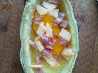 5、红薯奶酪焗蛋,洒一小部分奶酪和培根在鸡蛋上。