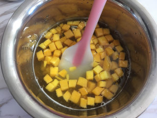 7、芒果水晶果冻,倒入芒果丁，搅拌均匀。