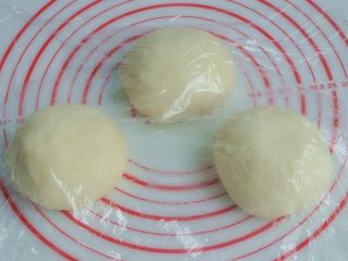 6、香肠吐司披萨,将面团取出，按揉排气后面团均分成三团，盖上保鲜膜松弛15分钟。