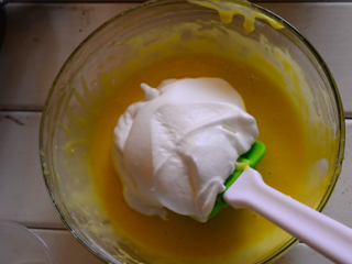 11、奶牛蛋糕卷,盛1/3蛋白到蛋黄糊中用橡皮刮刀轻轻翻拌均匀(从底部往上翻拌，不要划圈搅拌，以免蛋白消泡)，