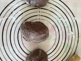 7、可可麻薯软欧,将面团轻压排气后平均分成3份，盖上保鲜膜松弛20分钟。