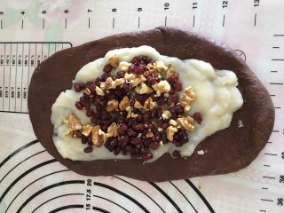 10、可可麻薯软欧,擀平抹上麻薯、红豆沙，均匀地放上蔓越梅干和核桃。