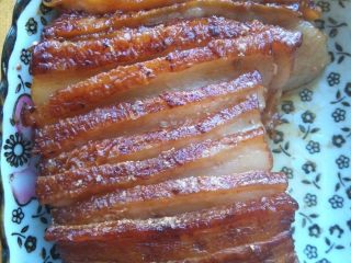 12、家常南乳扣肉,将汤汁倒在另外一锅里，用另一个盘子扣在上面，翻转方向，肉就扣进盘里了，此时肉皮朝上。为了让每片肉都入味，我把粘在一起的肉片稍稍分开了一点儿，