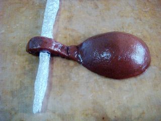 17、琵琶烧果子,拿起勺子,反扣到铺好不沾布的烤盘上。用锡纸做成小棒支撑起琴头,有弯弯的弧度更形象。