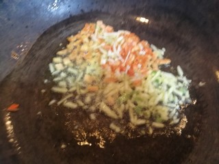 9、爆炒藕粒青椒肉,放入蒜碎，萝卜丁炒香。