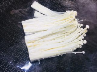 1、#懒人料理#茄汁酸甜金针菇,100克金针菇切掉头部，锅内烧水，放进金针菇煮熟，捞出控水摆盘备用。