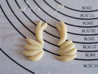 8、教你不用模具也可自制纯手工DIY月饼,另取一些皮捏出八只蟹脚和两个大钳子,并在油纸上排放好位置,这样做好的螃蟹方便转移放在烤盘上不变形