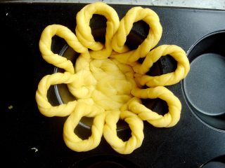 7、水果花篮面包,铺好一圈后，用擀面杖的一端，轻轻的压几下底部，每个面条都沾到一起，使底部更牢固。