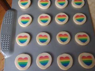 13、彩虹爱心饼干,取出冻好的面团,烤箱预热150度,面团切片,整齐地摆放在烤盘上,烤约12分钟。千万不要烤过头哈,烤过头颜色就不美貌了。