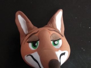 16、疯狂动物城翻糖杯蛋糕,另取橘色和棕色色素，调出眼皮的颜色，捏好眼皮，做好眼线。用白色和橘色复合成三角形，一端稍弯折如图中，安在耳朵相应的位置。