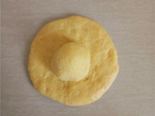 13、椰蓉花朵面包,松弛好的小面团压扁，包入椰蓉馅。