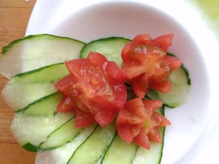 12、儿童蔬菜汤饭,黄瓜切薄片，圣女果从中间横向切开后，用刀刻出花瓣。
