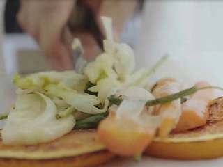 9、锋味纸包鱼,取两张烘焙纸,重叠放置,将三条边沿折叠做成纸包,然后将炒好的蔬菜放入纸包中。